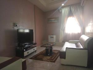 a living room with a couch and a tv at Nera Hotels in Jabi