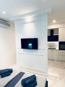 1 dormitorio con pared blanca y TV de pantalla plana en Studio Six, en Umag