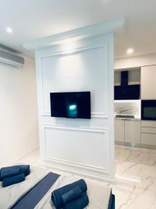 a bedroom with a white wall with a flat screen tv at Studio Six in Umag