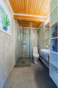 uma casa de banho com um chuveiro, um WC e um lavatório. em Senja Fjordcamp em Torsken