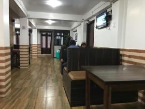 a person sitting at a table in a restaurant at Khangsangma Guest House in Darjeeling