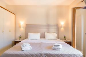 una camera da letto con un letto e due asciugamani di Lemon Tree Corfu Apartments by Konnect a Ipsos