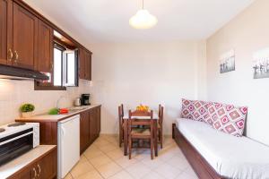 una piccola cucina con divano e tavolo di Lemon Tree Corfu Apartments by Konnect a Ipsos