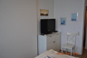 uma sala de estar com televisão numa cómoda em Apartment Meerblick em Bremerhaven