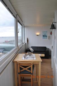 Zimmer mit einem Tisch, einem Sofa und einem Fenster in der Unterkunft Apartment Meerblick in Bremerhaven