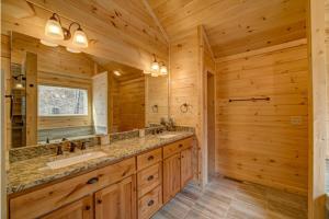 a log cabin bathroom with a double sink and a large mirror at Mystic Mountain Lodge in Mineral Bluff +22 photos