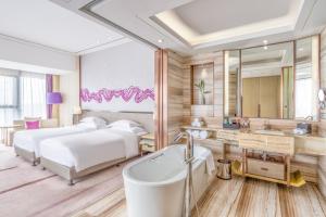 a bedroom with two beds and a bathtub and a mirror at Crowne Plaza Yibin, an IHG Hotel in Yibin