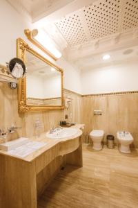 a bathroom with two sinks, a toilet and a mirror at Axelhof Boutique Hotel in Dnipro