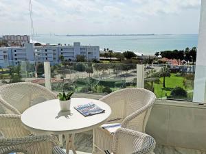 a table and chairs on a balcony with a view of the ocean at Apartamento Sea Views Las Redes in El Puerto de Santa María