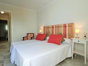 a bedroom with two beds with red pillows at Apartamento Sea Views Las Redes in El Puerto de Santa María