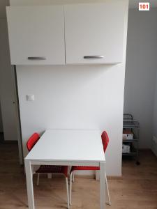 a white table and two chairs in a room at Immoappart in Albi