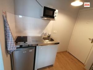 una pequeña cocina con fregadero y microondas en Immoappart, en Albi
