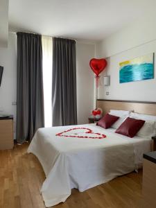 a bedroom with a bed with a red balloon on it at Hotel Royal in San Benedetto del Tronto