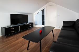 a living room with a black table and a black couch at Penthouse Leilighet TorskenSenteret in Torsken