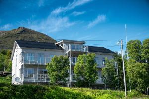 an apartment building with a hill in the background at Penthouse Leilighet TorskenSenteret in Torsken