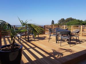 a deck with tables and chairs and a potted plant at Endless Horizons Boutique Hotel in Durban