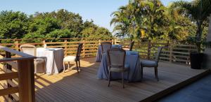 una terrazza in legno con tavoli e sedie. di Endless Horizons Boutique Hotel a Durban