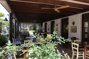 a patio with tables and chairs and a ceiling fan at Hotel La Pigna in Lignano Sabbiadoro