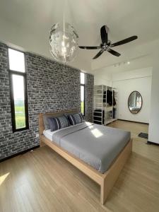 sypialnia z łóżkiem i ceglaną ścianą w obiekcie Sky Cafe Penthouse Suite by myProStay w mieście Alor Setar