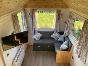 una sala de estar en una casa pequeña con sofá en The Cedar Tiny House, en Coldingham