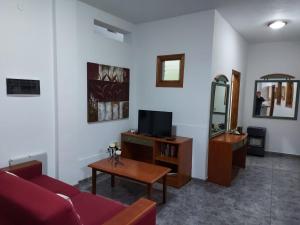 ein Wohnzimmer mit einem roten Sofa und einem Fernseher in der Unterkunft Casa Mari Carmen in Adeje