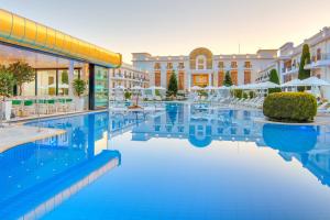a hotel swimming pool with a building in the background at Epirus Palace Congress & Spa in Ioannina