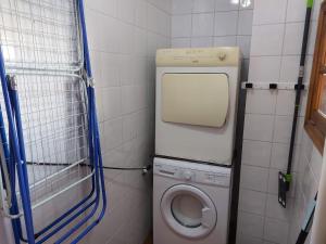 ein kleines Bad mit einer Waschmaschine und einem WC in der Unterkunft Casa Mari Carmen in Adeje