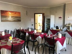 un ristorante con tavoli e sedie rossi e bianchi di Green Hotel a Poviglio