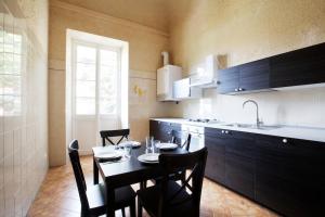 une cuisine avec une table et des chaises et une cuisine avec un évier dans l'établissement NORMA, à Levanto