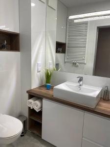 a white bathroom with a sink and a toilet at Bel Mare Comfort 305 Apartament in Międzyzdroje