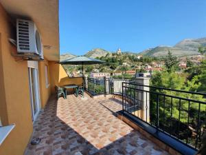 a balcony with a table and an umbrella at Apartman Nidžo in Trebinje