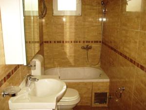 a bathroom with a sink and a toilet and a tub at Apartmani Becici in Becici