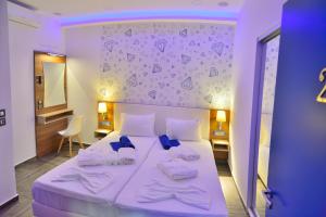 a bedroom with a white bed with a purple wall at Villa Zafyra in Kissamos +27 photos