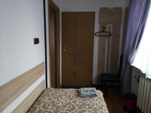 a small bedroom with a bed and a door at Mira Rent House in Warsaw