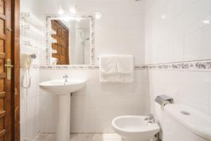 a white bathroom with a sink and a toilet at Arunda I in Ronda