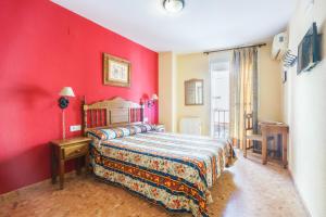 una camera con letto e parete rossa di Arunda I a Ronda