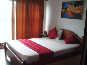 a bedroom with a bed with red pillows on it at Heaven Seven Kandy in Kandy