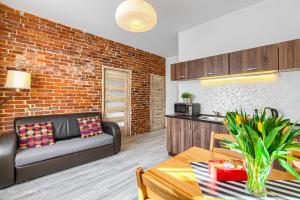 a living room with a couch and a brick wall at Apartment Zamulkowa Katowice in Katowice