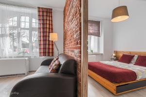 Un dormitorio con una cama y una pared de ladrillo. en Apartment Zamulkowa Katowice, en Katowice