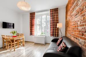 Una sala de estar con un sofá y una pared de ladrillos. en Apartment Zamulkowa Katowice, en Katowice