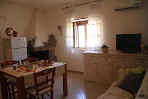 sala de estar con mesa y TV en Il Mandorlo en Ostuni