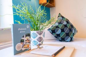 a table with a vase with a plant on it at Hotel kleine Auszeit - Adults Only in Sankt Peter-Ording