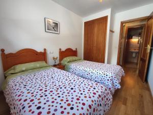 2 łóżka w małym pokoju z: w obiekcie Apartamento conques Linsoles / Benasque w mieście Eriste
