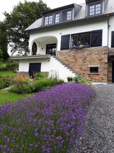 una casa con flores púrpuras delante de ella en L'Aubergine, en Sprimont