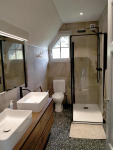 a bathroom with two sinks and a shower and a toilet at L'Aubergine in Sprimont