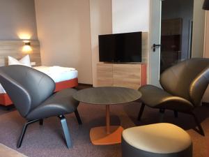 een hotelkamer met een bed en twee stoelen en een tafel bij Familienferienpark Dambeck in Kratzeburg