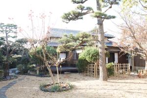a house in the middle of a yard with trees at Osaka Sakainoma hotel Hama in Sakai