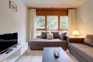 a living room with a couch and a large window at Eth Turcalh by Totiaran in Baqueira-Beret