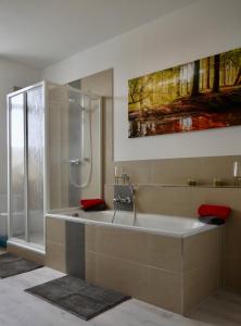 a bathroom with a bath tub and a shower at Ferienwohnung Ostard 1 in Thale