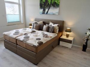 a bedroom with a large bed with a night stand at Ferienwohnung Ostard 1 in Thale +11 photos